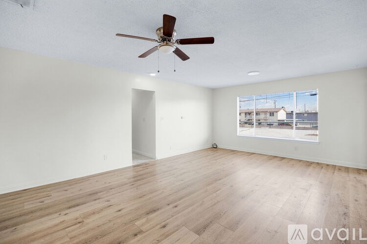 A room with a ceiling fan and wooden flooring.