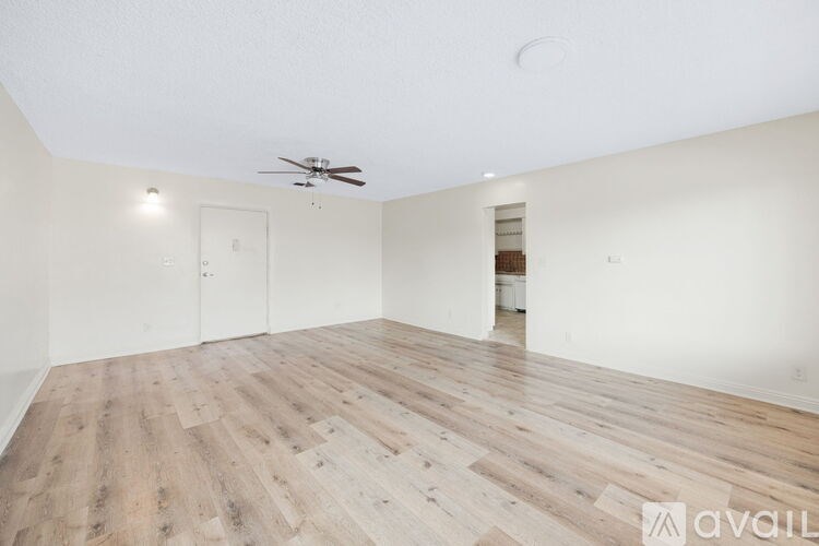 A room with wooden flooring and a ceiling fan.