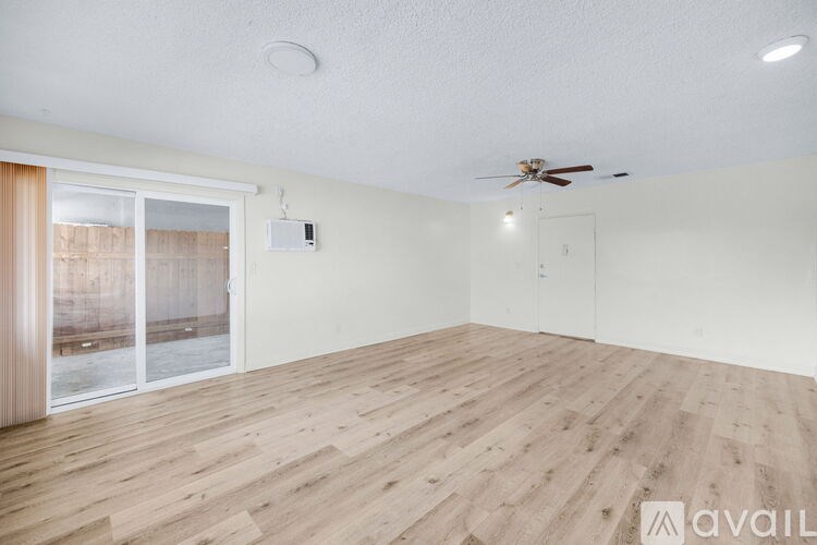 A room with wooden flooring and a ceiling fan.