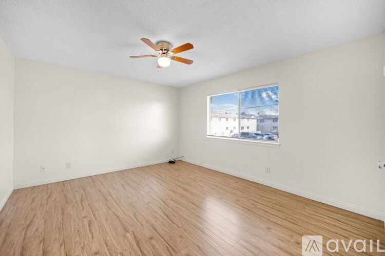 A room with a ceiling fan and wooden flooring.
