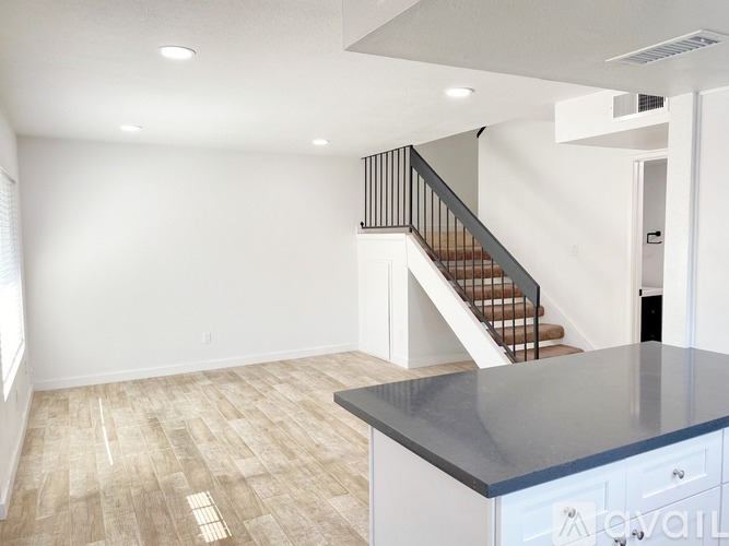 A spacious room with a staircase and a counter.