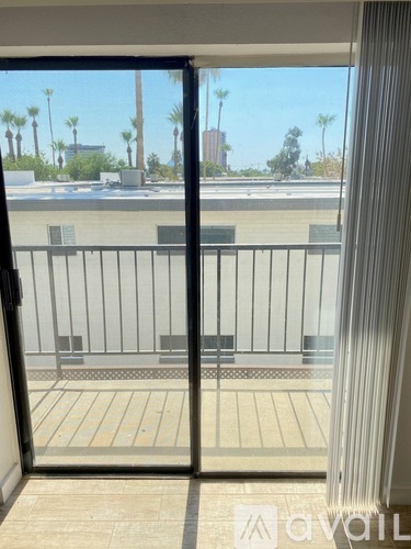 A balcony with a view of a pool and palm trees.