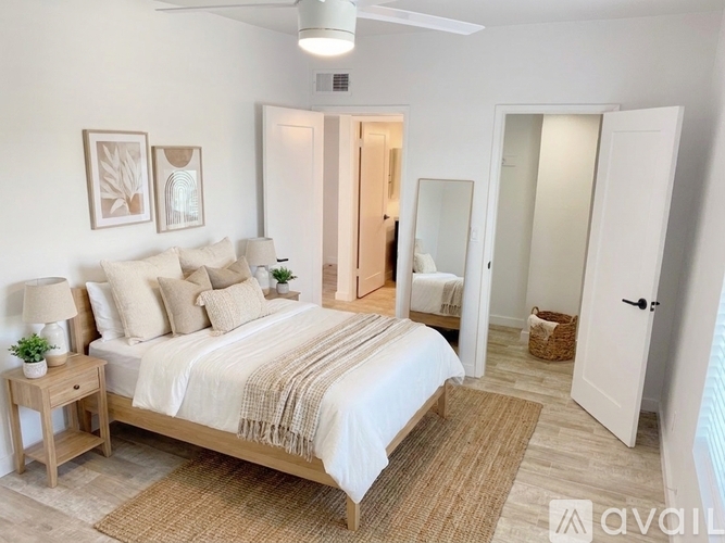 A bedroom with a bed, nightstand, and a rug.