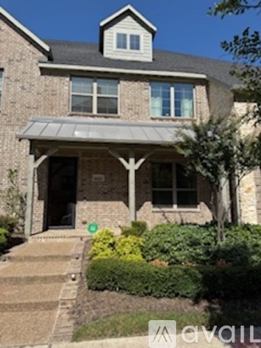 A house with a grey roof and a porch with a white railing.