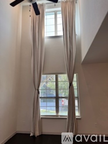 A room with a window and curtains.