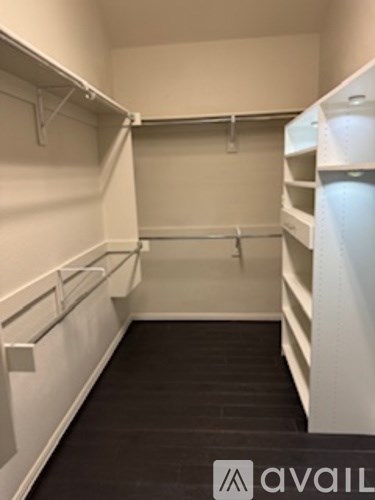 A white walk in closet with shelves and hangers.