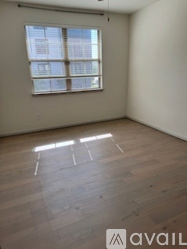 A room with wooden flooring and a window.