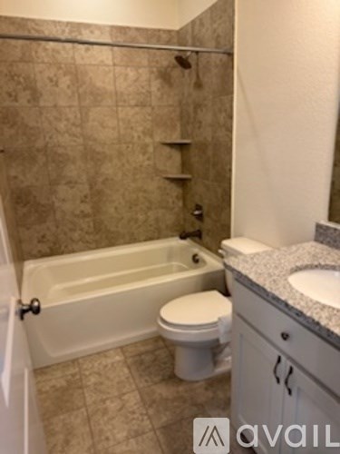 A bathroom with a tub, toilet and sink.