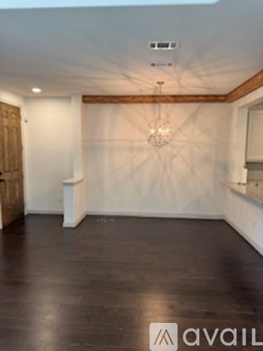 A room with wooden floors and a chandelier.
