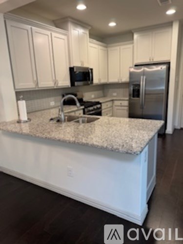 A kitchen with granite countertops and stainless steel appliances.