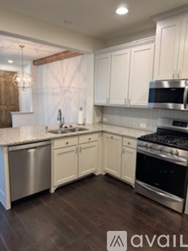 A kitchen with white cabinets and a stainless steel dishwasher.