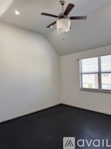 A room with a ceiling fan and a window.