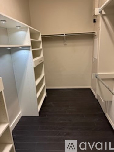 A room with white shelves and a black floor.
