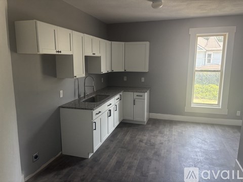 A kitchen with white cabinets and a window.