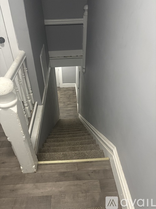 A staircase with a carpeted runner and white balusters.