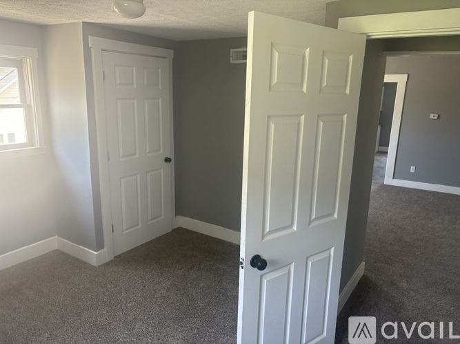 A room with two white doors and a carpeted floor.