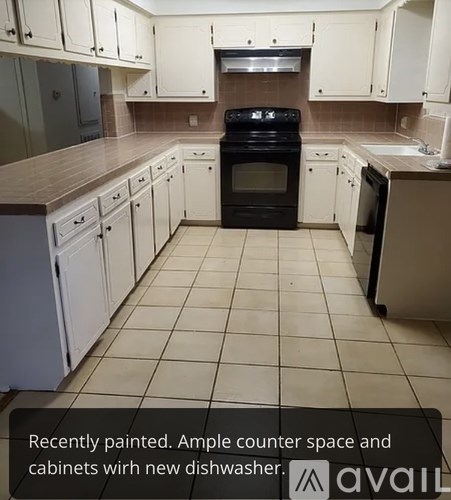 A kitchen with white cabinets and a black stove top oven.