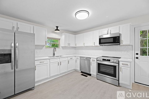 A kitchen with white cabinets and stainless steel appliances.
