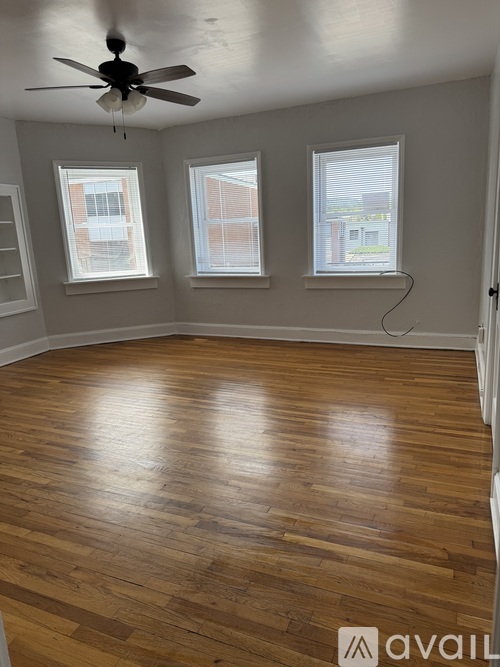 A room with wooden flooring and a ceiling fan.