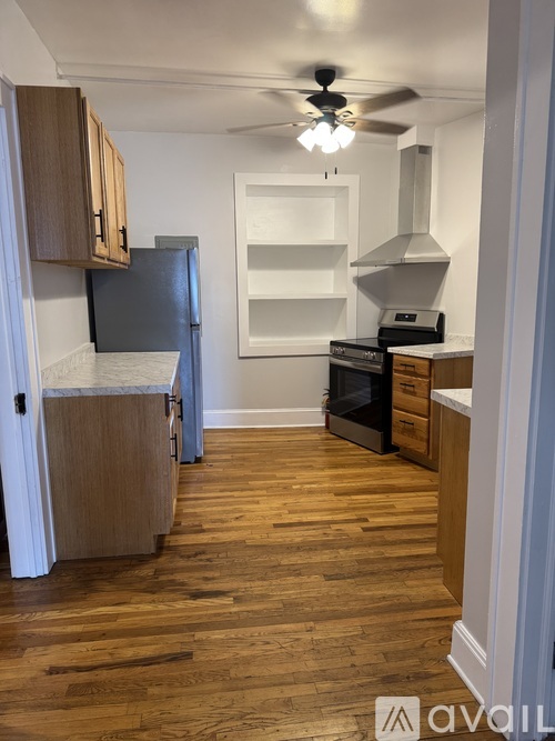 A kitchen with wooden floors and a ceiling fan.