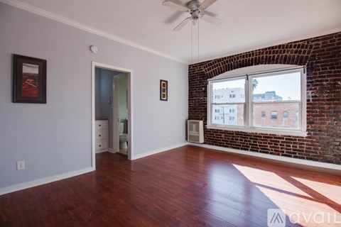 A room with a brick wall and a ceiling fan.