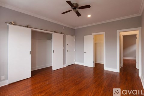 A room with a ceiling fan and sliding doors.