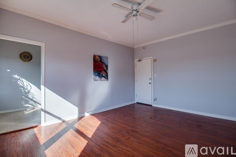A room with wooden floors and a ceiling fan.