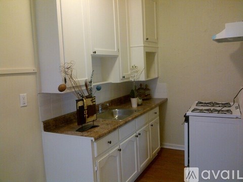 A kitchen with white cabinets and a granite countertop.
