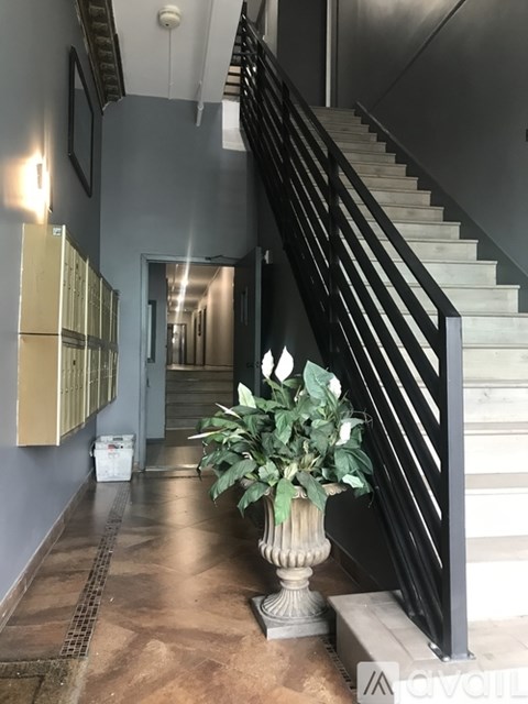 A plant in a white pot sits on a step next to a staircase.