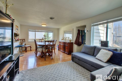 A living room with a grey couch and a wooden floor.