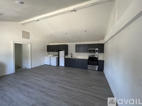 A spacious kitchen with dark wood flooring and modern appliances.