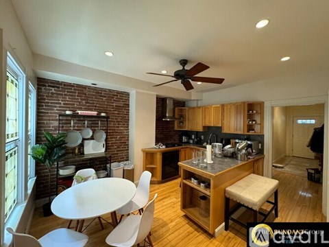 A kitchen with a table and chairs in front of a brick wall.