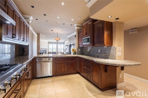 A kitchen with brown cabinets and a granite countertop.