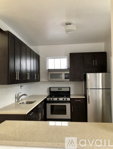 A kitchen with black cabinets and stainless steel appliances.