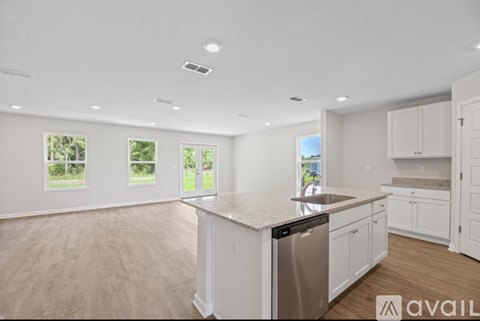 A kitchen with white cabinets and a stainless steel dishwasher.