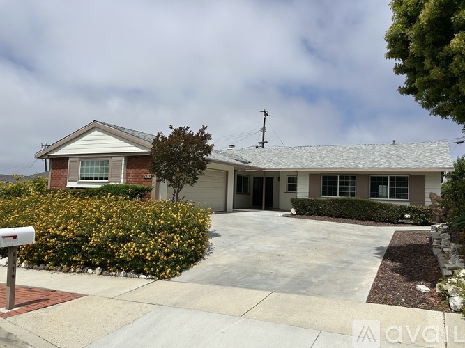 A house with a grey roof and a mailbox in front.