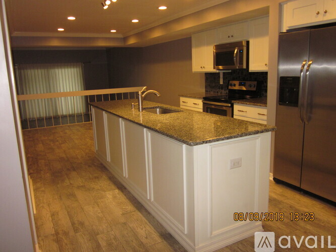 A kitchen with a granite countertop and stainless steel appliances.