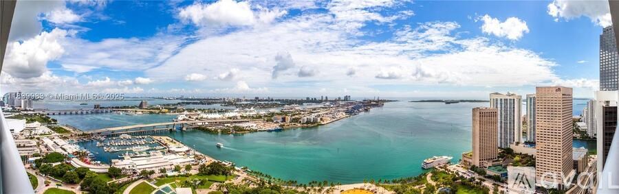 A cityscape with a body of water in the foreground and buildings of varying heights.