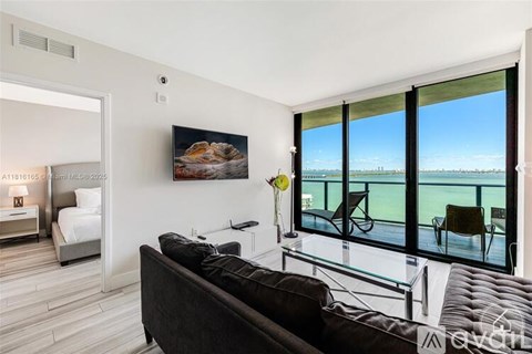 A modern living room with a large couch and a view of the ocean.
