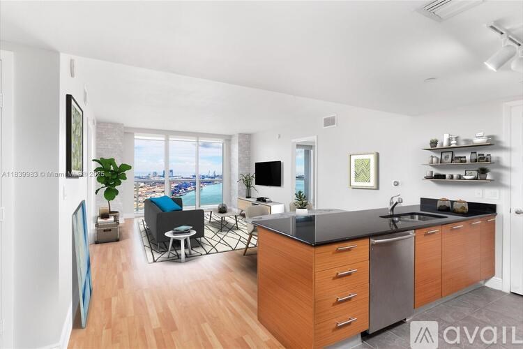 A modern kitchen with wooden cabinets and a large window overlooking the city.