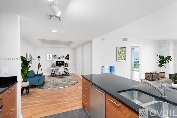 A modern kitchen with a blue sofa and a dining table.