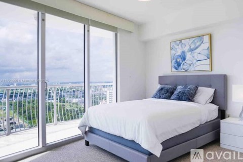 A bedroom with a large bed and a view of the outside.