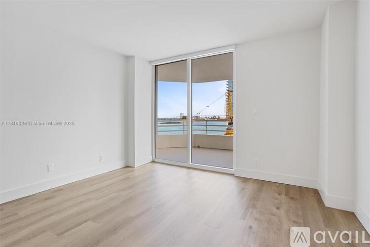 A room with a sliding glass door leading to a balcony.