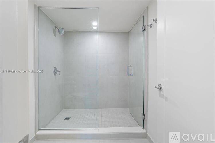 A white bathroom with a glass shower door.