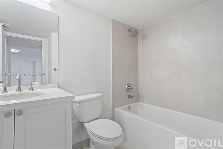 A white bathroom with a toilet, sink, and bathtub.