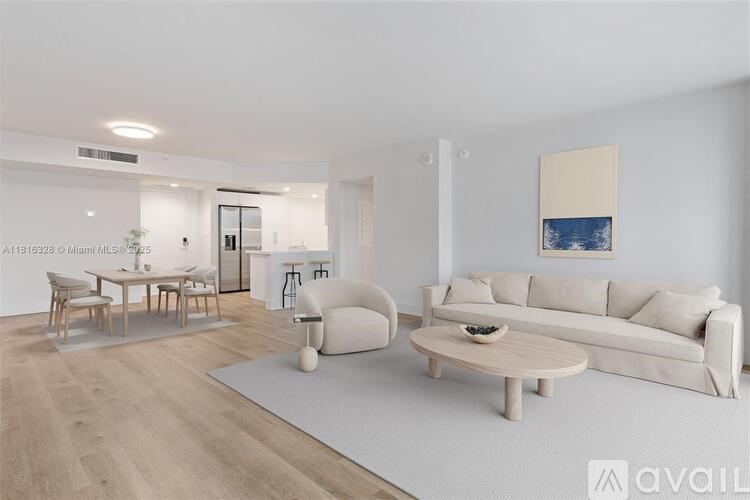 A modern living room with a white sofa, wooden coffee table, and a painting on the wall.