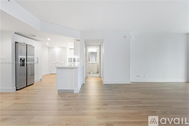 A spacious kitchen with a refrigerator, sink, and countertops.