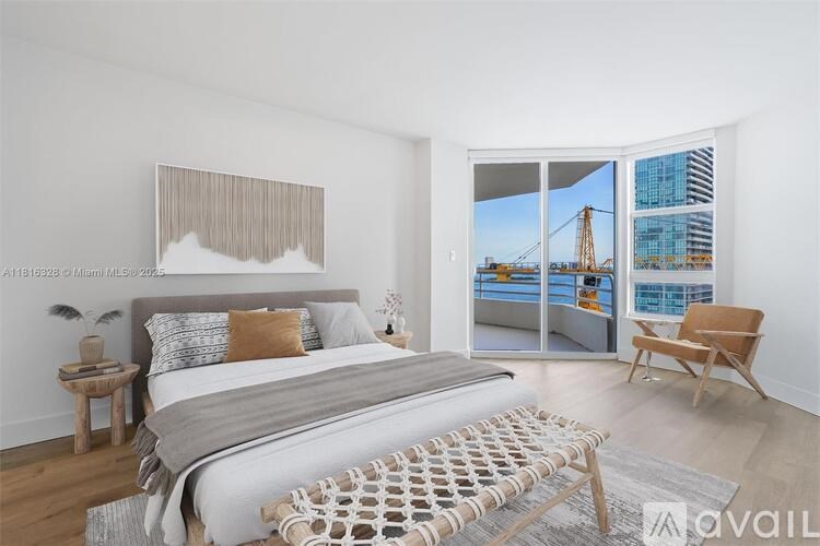 A bedroom with a large bed and a view of a bridge outside the window.