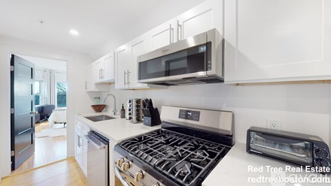 A modern kitchen with a stove top oven and a microwave above it.