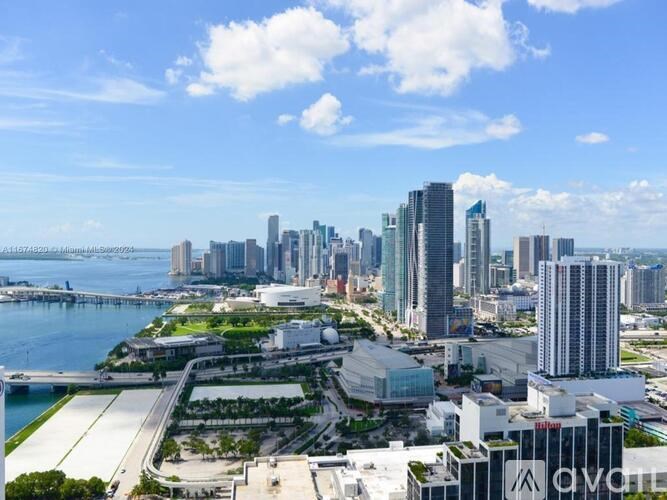 A cityscape with a bridge in the background and a clear blue sky.